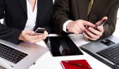 Según jóvenes empresarios, los smartphones son la herramienta más importante para la gestión del negocio Ejecutivos mujer y hombre con smartphones