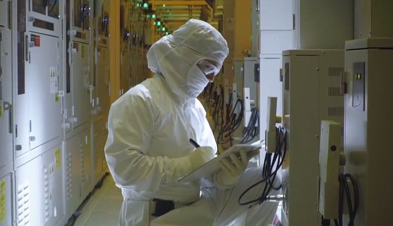 Fotograma presentación en YouTube de la tecnologia de 14 nanómetros de Intel. Científico toma apuntes mientras observa un sistema.