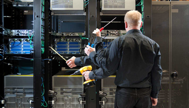 Técnico observa racks de servidores con imagen trucada que muestra su brazo izquierdo sosteniendo distintas herramientas.