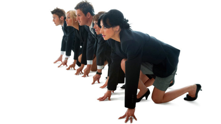 Grupo de ejecutivos, hombres y mujeres, se preparan para competir corriendo