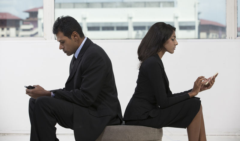Dos ejecutivos indios, hombre y mujer, con smartphones
