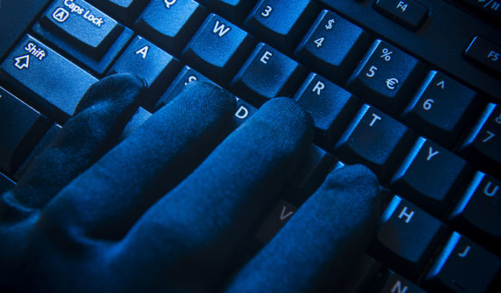 Guante negro sobre teclado cibercrimen