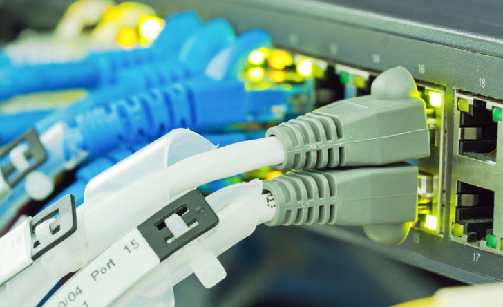 Cables ethernet con conector gris conectados a equipo.