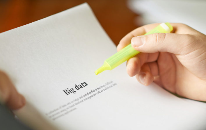 Definición de Big Data en inglés y mano con marcador amarillo