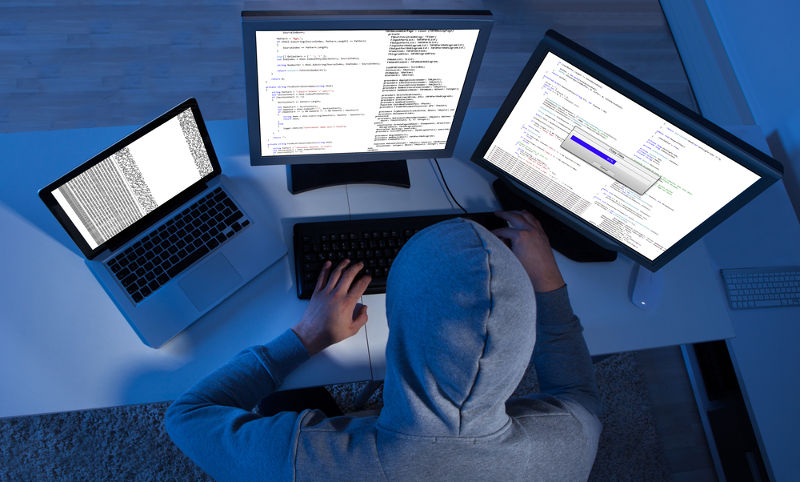 Hacker utilizando varias computadoras para robo y sabotaje cibernético