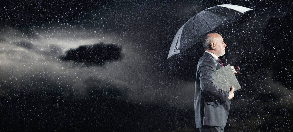 Hombre de negocios con paraguas en la lluvia